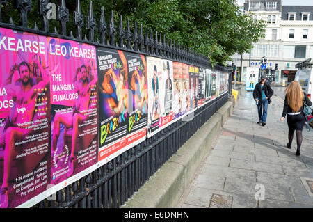 I pedoni a piedi passato Edinburgh Fringe Festival attaccato alle ringhiere in ferro sulla Montagnola. Foto Stock