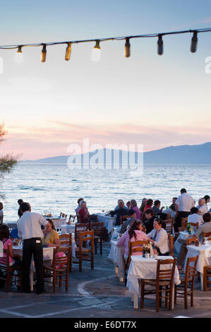 Le persone al di fuori di ristoranti sul lungomare di Kastro Mykonos Grecia Foto Stock