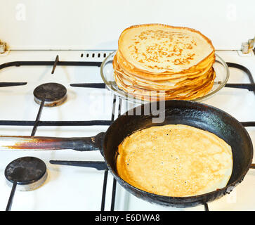 Pancake cotto in padella e pila di pancakes preparati Foto Stock