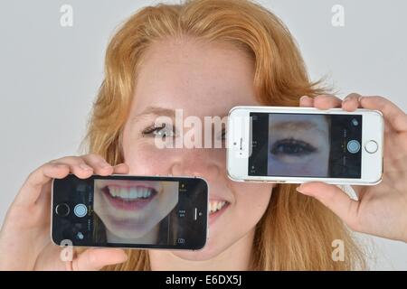 Ritratto di un auburn teen prendendo un autoritratto con un telefono. Foto Stock