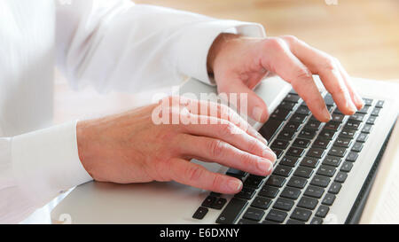 Uomo maturo digitando sulla tastiera del notebook. Close-up. Foto Stock