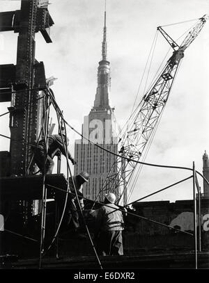 Lavoratori di demolizione rimozione rimane della Pennsylvania Station con Empire State Building in background, New York, USA, 1966 Foto Stock