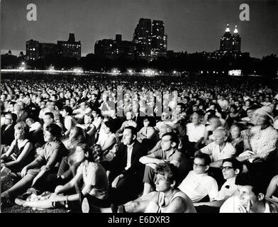 Grande folla ascoltare musica classica eseguiti da New York Philharmonic Orchestra di notte, al Central Park di New York City, Foto Stock