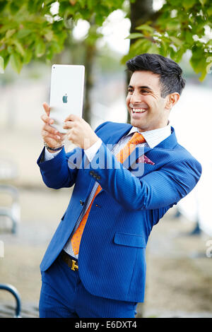 Uomo di scattare una foto con iPad Foto Stock