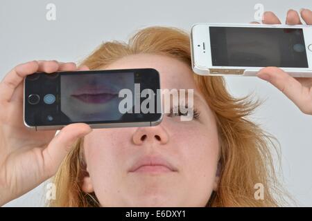 Ritratto di un auburn teen prendendo un autoritratto con un telefono. Foto Stock