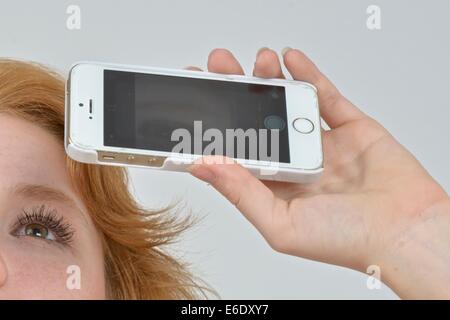 Ritratto di un auburn teen prendendo un autoritratto con un telefono. Foto Stock