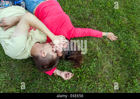 Una coppia giacendo sull'erba nel parco Foto Stock