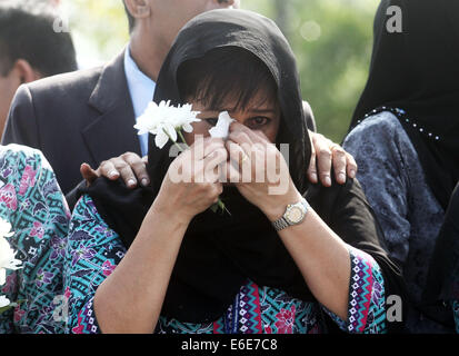 Sepang, Selangor, Malaysia. Il 22 agosto, 2014. Malaysia Airlines assistenti di volo grido come un convoglio di carri funebri che trasportano i resti delle vittime della Malaysia Airlines MH17 piano, lasciare Bunga Raya complesso a Sepang il 22 agosto 2014. Un piano portante il primo rimane del 43 malesi uccisi in MH17 disaster sono tornati a casa, dove dovevano essere sombrely ricevuto su una giornata di lutto nazionale. Credito: Kamal Sellehuddin/ZUMA filo/Alamy Live News Foto Stock