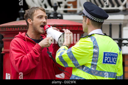 Regno Unito, Londra : un funzionario di polizia remonstrates con un manifestante su una strada nel corso di una manifestazione a Londra. 18.08.2014 Foto Stock