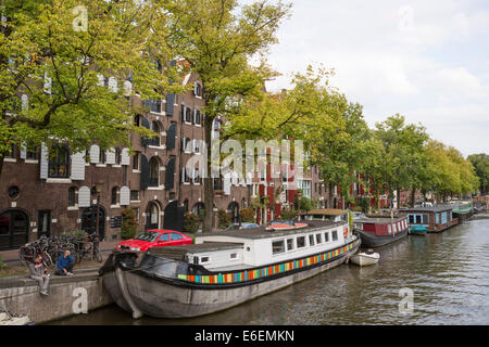 Le persone in un momento di relax a lato di uno dei canali (Prinsengracht) ad Amsterdam nei Paesi Bassi Foto Stock