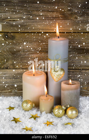 Festa di Natale decorazione in oro e bianco: quattro red burning avvento candele su sfondo di legno. Foto Stock