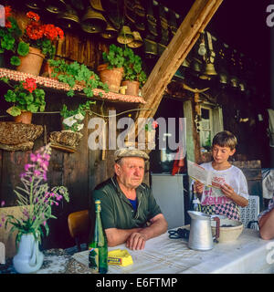 Anziani agricoltori di montagna con il nipote di fronte al loro chalet Savoia sulle Alpi francesi Francia Foto Stock