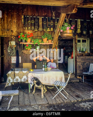 Agricoltore di montagna anziano che guarda con binocoli e nipote di fronte al loro chalet Savoia Alpi francesi Francia Europa Foto Stock