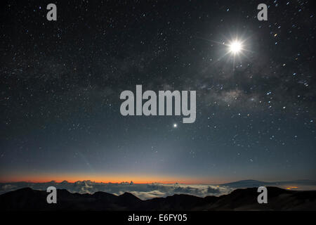 All'alba, la Via Lattea, Luna e Venere dal vertice di Haleakala, Hawaii. In lontananza le vette del Mauna Kea (sinistra) Foto Stock