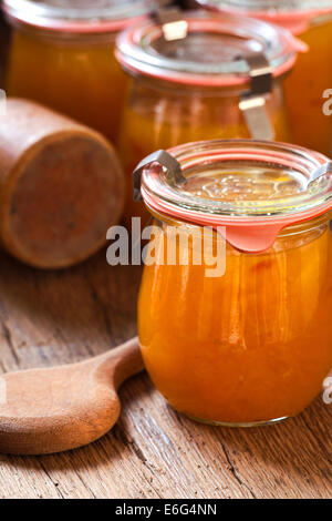 In casa il melone marmellata in un barattolo di conservazione su rustico sfondo in legno in stile country Foto Stock