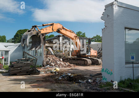 Escavatore con benna mordente facendo lavori di demolizione su edificio per uffici a Norwalk, CT. Materiali ordinati per il riciclaggio. Foto Stock