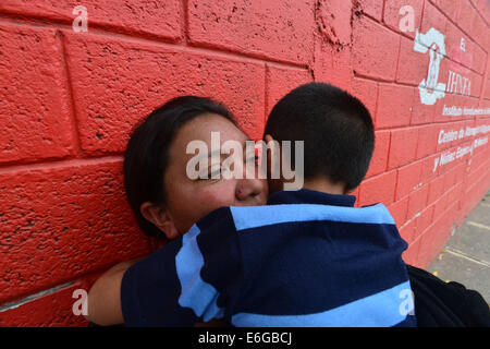 San Pedro Sula, Cortez, Honduras. 28 Luglio, 2014. Sandra Herrera hols suo figlio John Terry come ella attende un autobus che trasportava il suo figlio più anziano, Alex Fernando, per arrivare a un migrante Processing Center di San Pedro Sula dopo la deportazione cercando di raggiungere gli Stati Uniti © Miguel Juarez Lugo/ZUMA filo/Alamy Live News Foto Stock