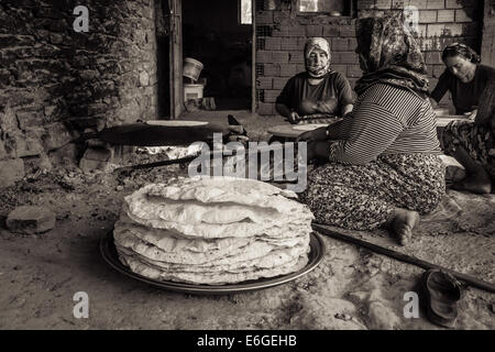 EVRENLERYAVSI, Turchia - 24 giugno 2014: le donne del villaggio tradizionale di preparare focacce su un fuoco aperto. Seppia Foto Stock