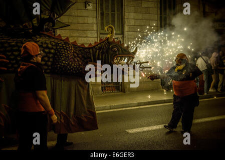 Un membro di 'la Vella de Gràcia' lits draghi petardi durante il 'Correfocs' a 'Festa Major de Gracia'. © matthi/Alamy Live News Foto Stock