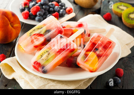 Una sana frutta intera Popsicles con frutti di bosco Kiwi e pesche Foto Stock