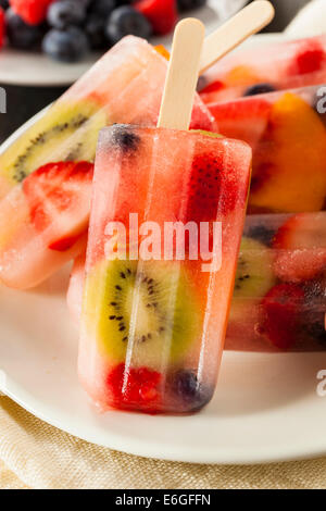 Una sana frutta intera Popsicles con frutti di bosco Kiwi e pesche Foto Stock