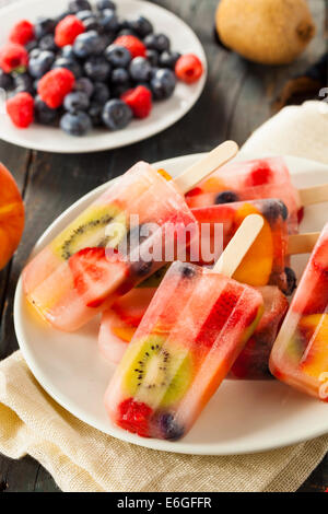 Una sana frutta intera Popsicles con frutti di bosco Kiwi e pesche Foto Stock