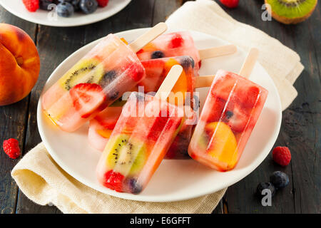 Una sana frutta intera Popsicles con frutti di bosco Kiwi e pesche Foto Stock