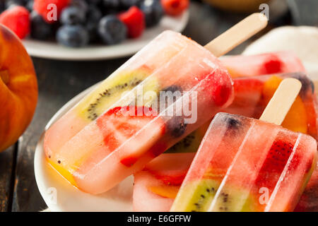 Una sana frutta intera Popsicles con frutti di bosco Kiwi e pesche Foto Stock