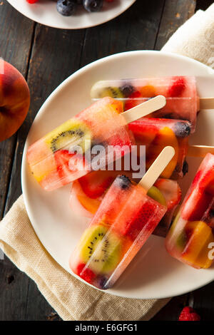 Una sana frutta intera Popsicles con frutti di bosco Kiwi e pesche Foto Stock