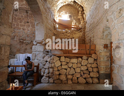 Damasco, Siria. 21 Ago, 2014. Una donna si siede in una chiesa nella storica cittadina cristiana di Maaloula, a nord di Damasco Capitale della Siria, e il agosto 21, 2014. Maaloula è una delle più antiche culle del cristianesimo in Siria dove intensi scontri hanno avuto luogo tra l'esercito siriano e i gruppi ribelli. Il 14 aprile 2014, il governo siriano truppe riprendeva il controllo di Maaloula che fu espugnata dai ribelli lo scorso anno. Fin circa 150 famiglie di Maaloula sono tornati a casa. © Zhang Naijie/Xinhua/Alamy Live News Foto Stock