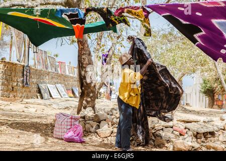 Dakar, Senegal. Il 22 agosto, 2014. Un uomo si blocca i suoi abiti su una strada dell'isola di Goree, tre chilometri a est di Dakar, capitale del Senegal, 22 Agosto, 2014. Isola di Goree, rinomata per il suo commercio atlantico dello schiavo della storia, è una delle destinazioni più popolari per i turisti in Senegal. © Li Jing/Xinhua/Alamy Live News Foto Stock