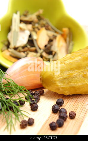 Cetriolo sottaceto con spezie per il decapaggio di cetrioli giacente sul tagliere di legno Foto Stock