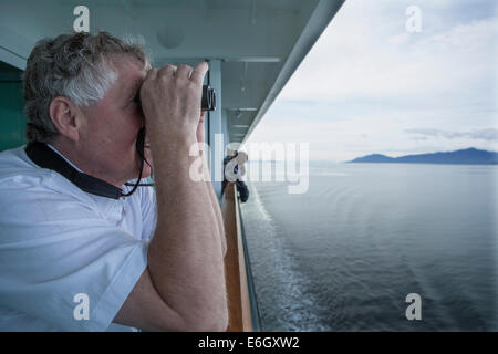 George Twarski guarda si gode della vista del passaggio interno dal suo balcone privato sul bordo della norvegese Perla, una nave da crociera Foto Stock