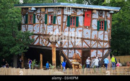 Thale, Germania. 23 Ago, 2014. Supporto di persone al di fuori della nuova casa della strega sulla danza strega piazza durante il primo periodico giornata dei visitatori in Thale, Germania, 23 agosto 2014. 500.000 euro è stato investito nella casa che ha tutto il suo arredamento sul soffitto. La nuova attrazione turistica aperta oggi e che è destinato ad aumentare il carattere mistico di danza strega square. Foto: Jens WOLF/dpa/Alamy Live News Foto Stock