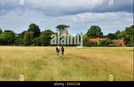 Signora Ramblers su un rurale inglese attraverso un prato con in The Chiltern village di Hambleden Foto Stock