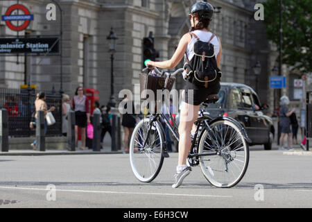 Un ciclista di attesa nel mezzo di una strada girare a destra Foto Stock