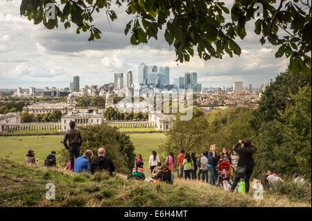 London, Regno Unito - 23 August 2014: i visitatori godere la vista del Canary Wharf grattacieli da Greenwich Park a Londra Foto Stock