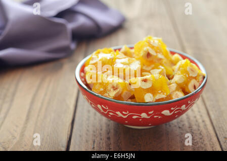 Delizie turche con i dadi nel recipiente di ceramica su sfondo di legno Foto Stock