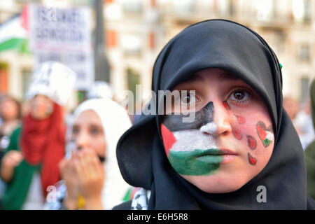 Giovane donna con una bandiera della Palestina dipinta sul suo viso per protestare contro gli attacchi israeliani nella Striscia di Gaza durante un demonstratio Foto Stock