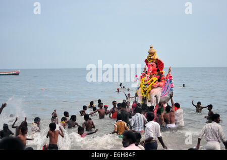 Popolo Indiano che porta un Ganesh scultura in mare durante il Ganesh Chaturthi celebrazione in Rameswaram, India. Foto Stock