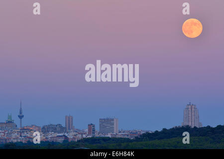 La luna piena appare al suo più vicino incontro con messa a terra per l'anno come sorge oltre la skyline di Madrid, un fenomeno che è Foto Stock