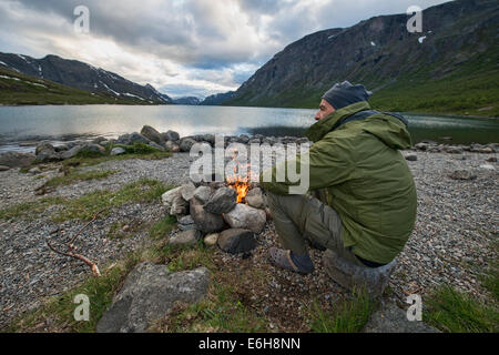 Seduto accanto al fuoco nel Parco nazionale di Jotunheimen, Norvegia Foto Stock