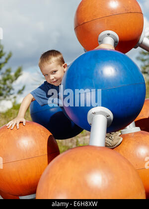 6 anno vecchio ragazzo salendo sul parco giochi Foto Stock