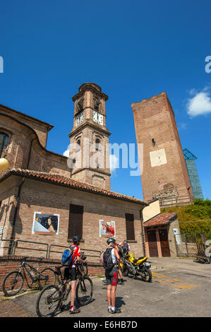 Italia Piemonte Langa del Barbaresco ciclisti e la chiesa parrocchiale di San Giovanni Battista Foto Stock