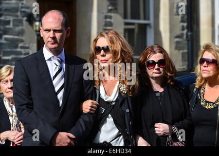 Derry, Londonderry, Irlanda del Nord - 24 agosto 2014. Funerali di emittente Gerry Anderson. Christine Anderson (centro) vedova del broadcaster Gerry Anderson con i loro figli David e Kirsty frequentando il servizio funebre a san Eugenio la Cattedrale cattolica romana. Gerry Anderson's broadcasting una carriera di 30 anni programmi di hosting per BBC Radio 4, BBC Radio Ulster, BBC Radio Foyle e BBC Irlanda del Nord la televisione. Credito: George Sweeney / Alamy Live News Foto Stock