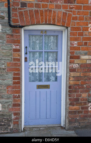 Il numero blu 64 in legno porta anteriore del periodo casa a schiera in Brecon Galles POWYS REGNO UNITO Foto Stock