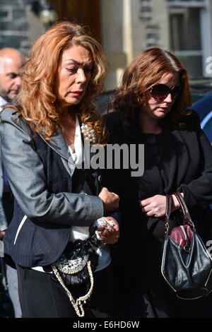 Derry, Londonderry, Irlanda del Nord - 24 agosto 2014. Funerali di emittente Gerry Anderson. Christine Anderson vedova del broadcaster Gerry Anderson, con la loro figlia Kirsty, frequentando il servizio funebre a san Eugenio la Cattedrale cattolica romana. Gerry Anderson's broadcasting una carriera di 30 anni programmi di hosting per BBC Radio 4, BBC Radio Ulster, BBC Radio Foyle e BBC Irlanda del Nord la televisione. Credito: George Sweeney / Alamy Live News Foto Stock