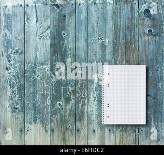 Vista superiore del foglio quadrato del notebook su blu rustico tavolo in legno. Spazio di copia Foto Stock