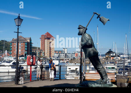 Capitano Cat statua (Dylan Thomas sotto latte carattere di legno) con i turisti scattano fotografie dietro Swansea Marina Wales UK Foto Stock