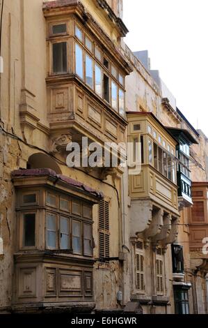 Una fila di maestosi edifici di vecchia costruzione nel centro di La Valletta, Malta, un sito patrimonio mondiale dell'Unesco, con stile ottomano balconi Foto Stock